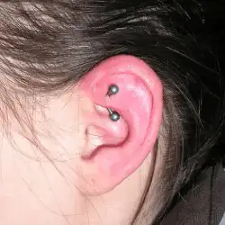 Une fille nous présente son perçage dans le cartilage de son oreille gauche un rook piercing.