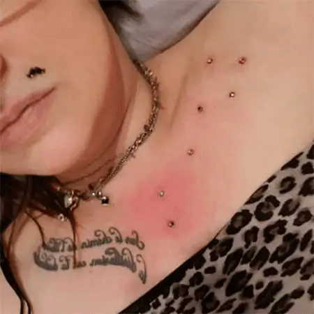 Il n'y a pas moins de 7 piercings microdermal en forme d'étoile La Casserole sur le chest de cette jeune femme.
