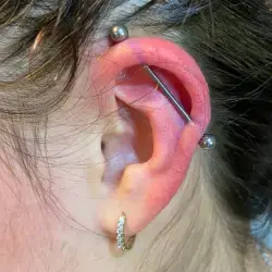 Oreille gauche d'une jeune venant tout juste de se faire percer un piercing industriel chez Yan Dubord Massotherapeute Perceur au centre-ville de Montreal.